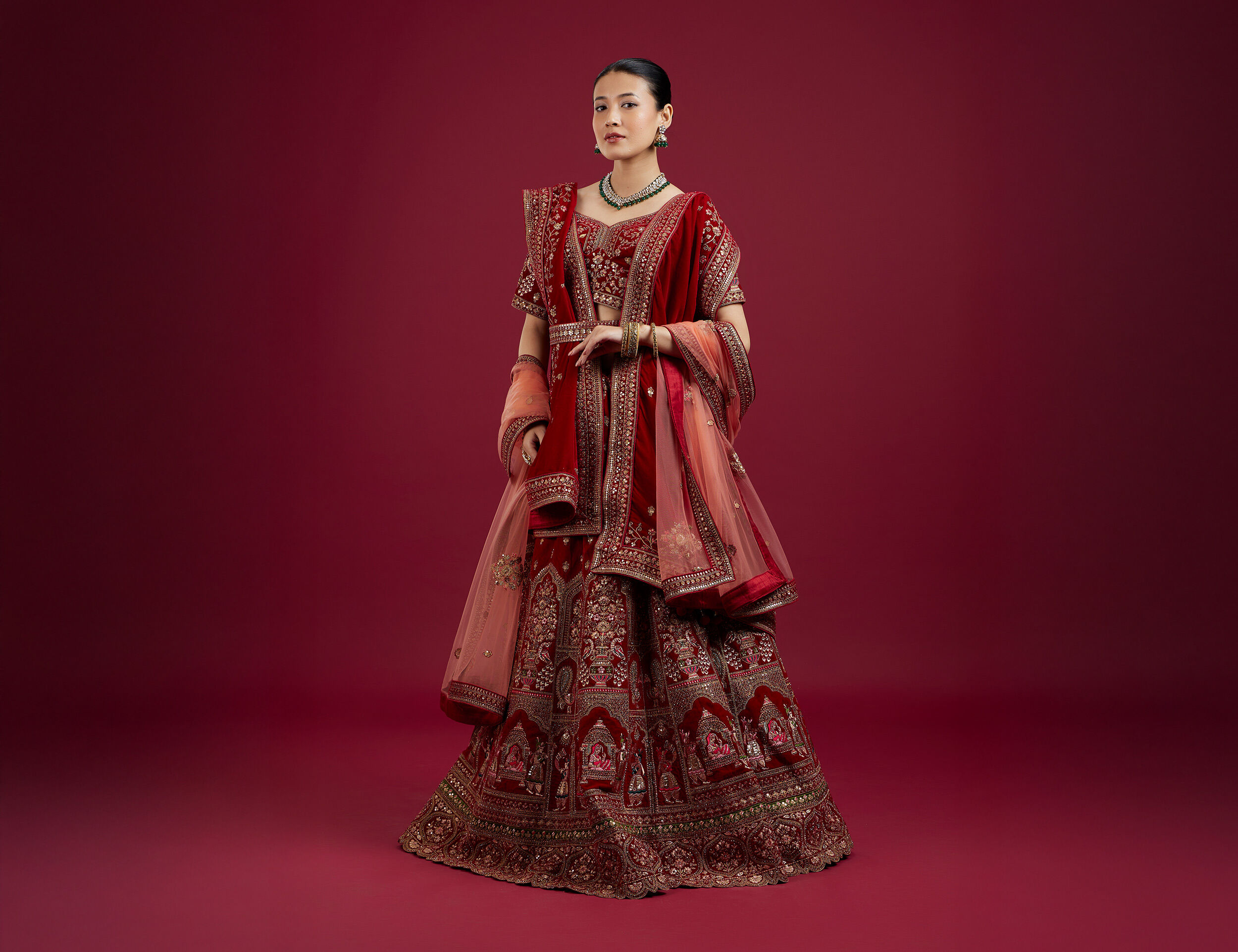 Bride in deep red lehenga showcasing intricate textures and fabric play